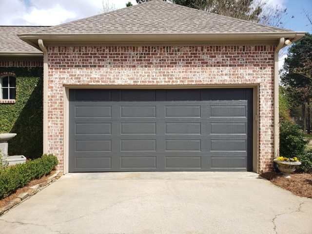 A brick garage with a dark gray double door.