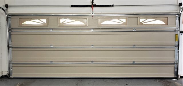 Beige garage door with upper window panels. Beige garage door with upper window panels.
