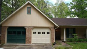A house with a green garage door and a white garage door.