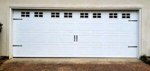 A white garage door with a lot of windows is open.