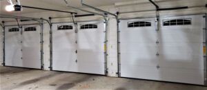 A row of white garage doors are open in a garage.