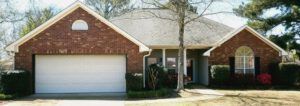 A red brick house with a white garage door