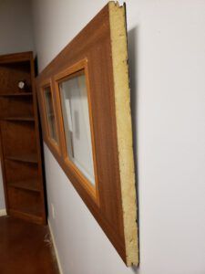 A picture frame is hanging on a wall next to a bookshelf.