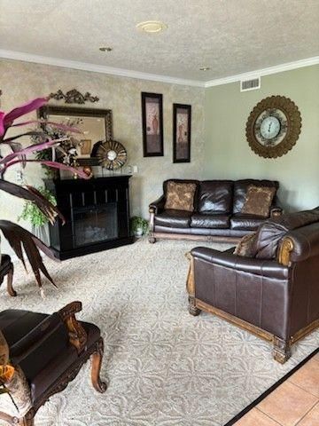 A living room features brown leather couches, a fireplace with a mirror above it, and a large decorative wall clock.