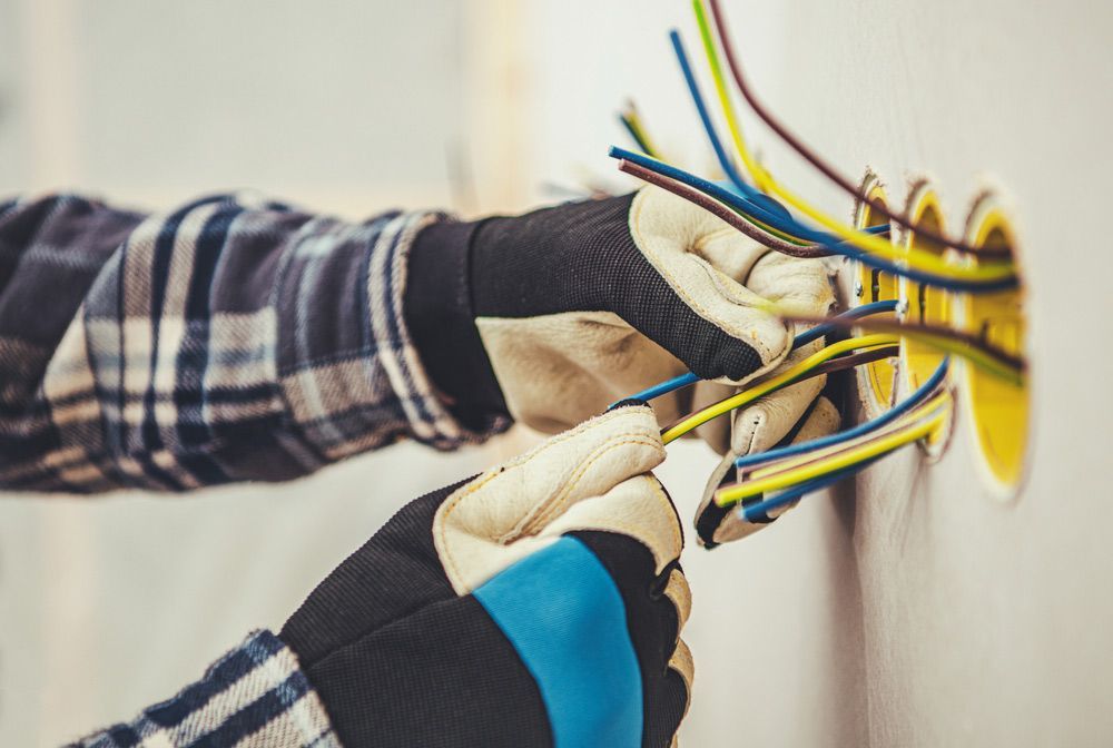 Man Installing Electrical Wires Into A Wall — RAFFBRO Electrical Solar & Air Conditioning In Chiltern, VIC