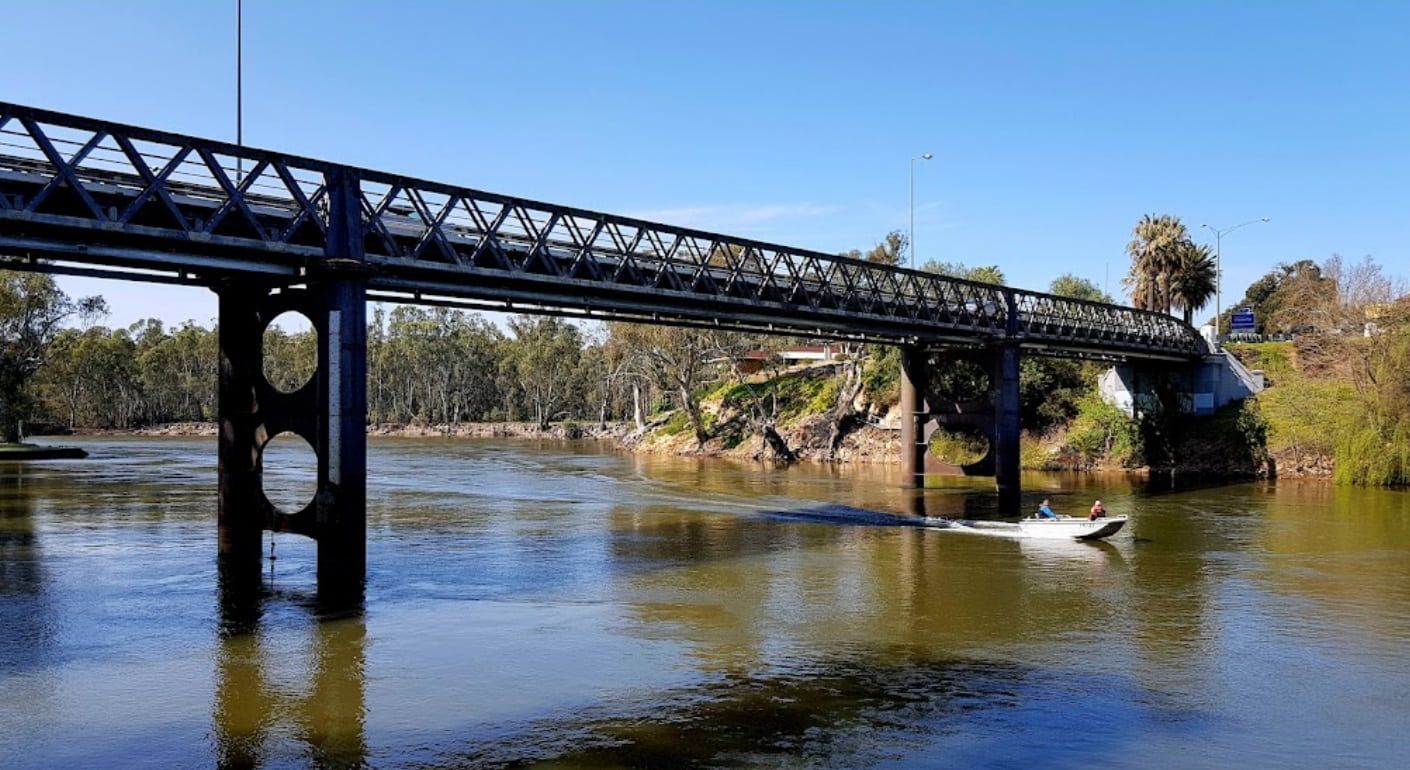 A Boat Is Going Under A Bridge Over A River — RAFFBRO Electrical Solar & Air Conditioning In Corowa, NSW