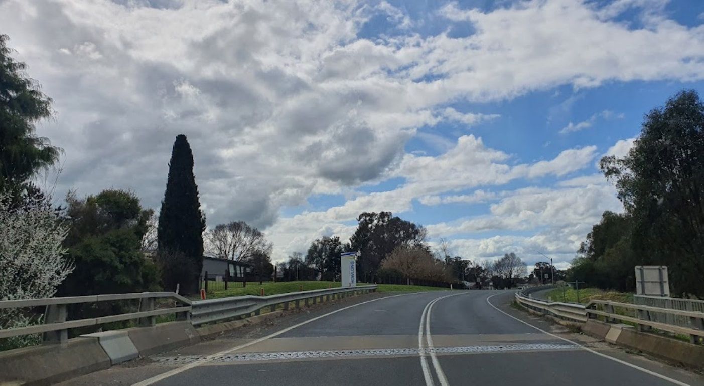 A Car Is Driving Down A Road On A Cloudy Day — RAFFBRO Electrical Solar & Air Conditioning In Howlong, NSW