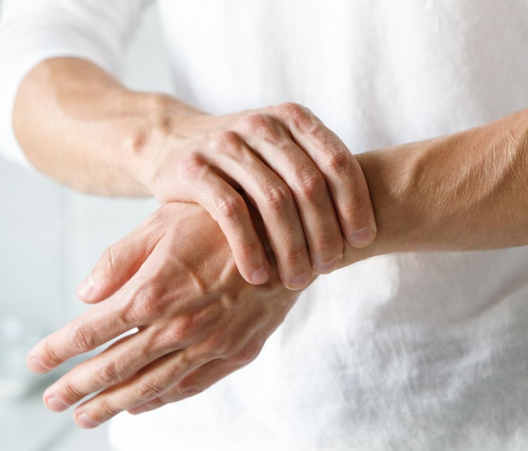 Person holding a wrist with the other hand, suggesting wrist pain or injury
