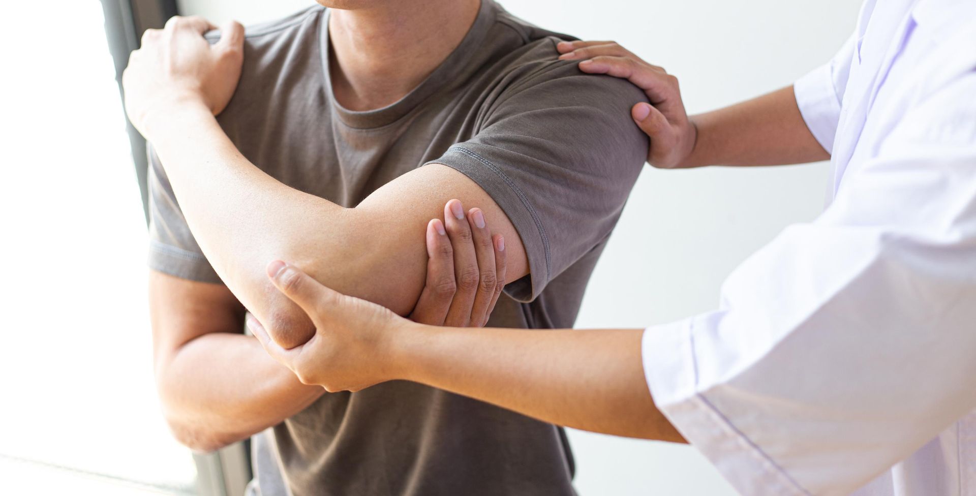 Person with shoulder pain receiving examination by a medical professional