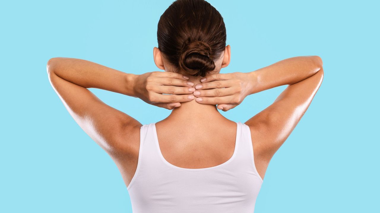 Massage therapist working on a woman’s upper back and shoulder on a massage table