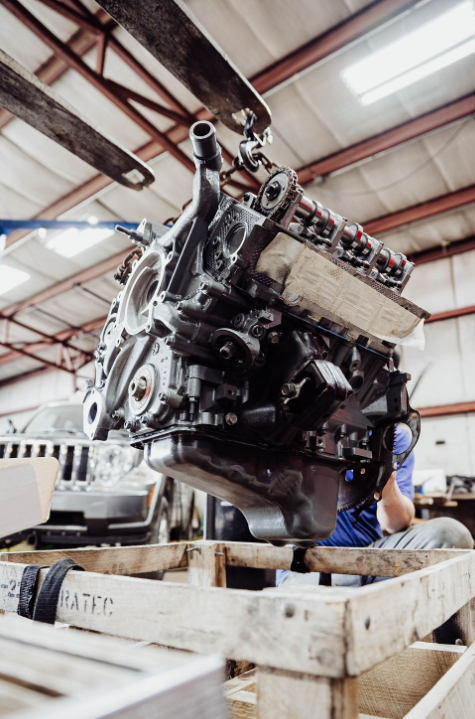 A close up of a car engine with an alternator and belt.