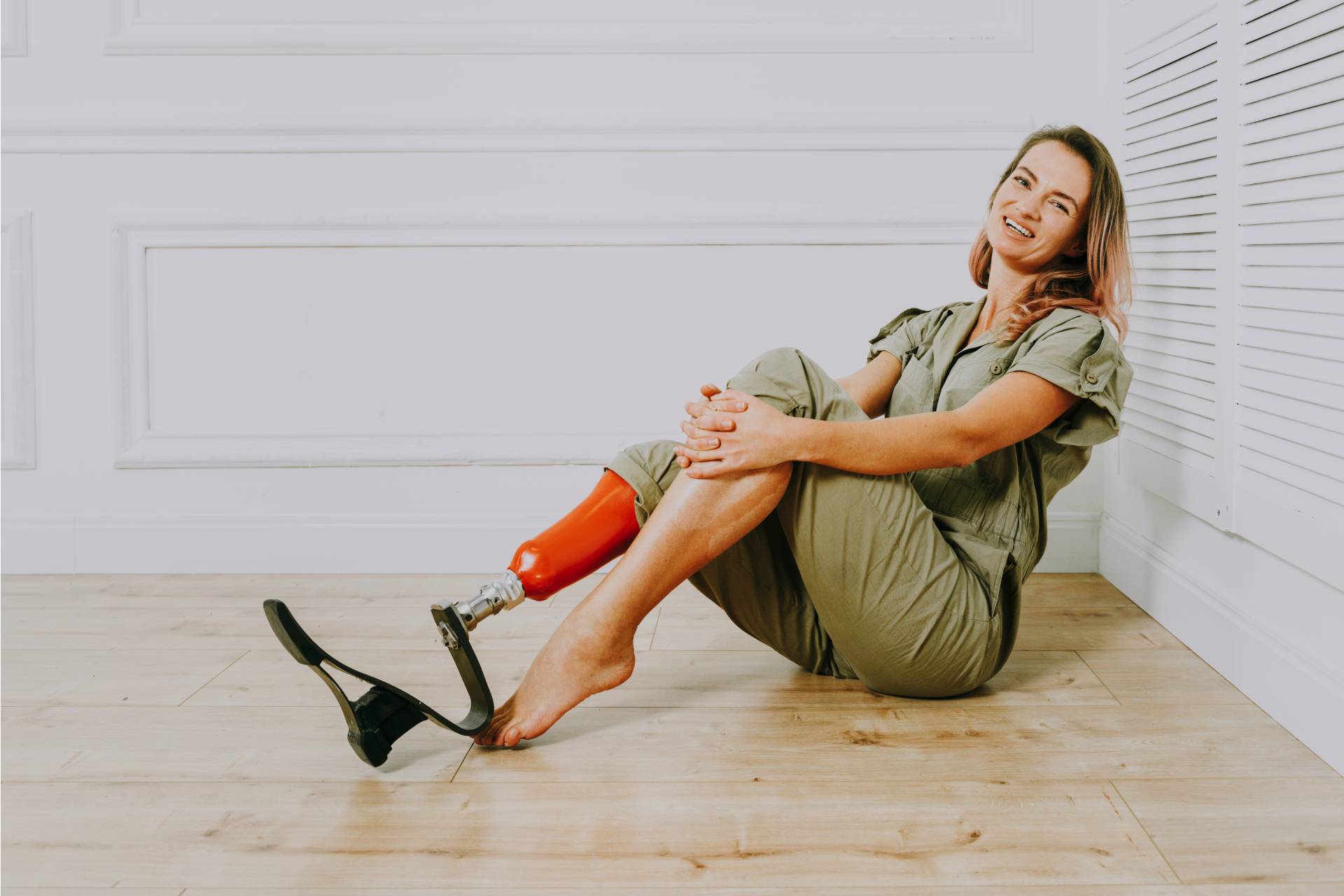 Woman with prosthetic leg using a modified device to put on shoe their home