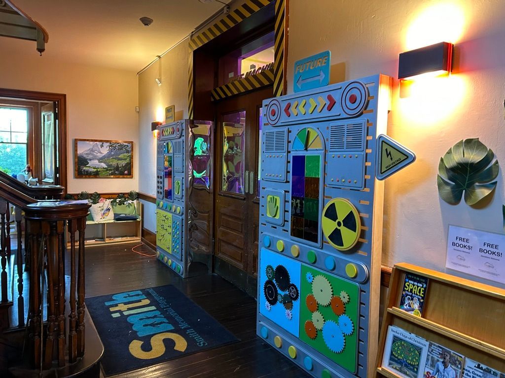 Bright hallway with colorful children’s activity boards and wall art in a museum or school setting