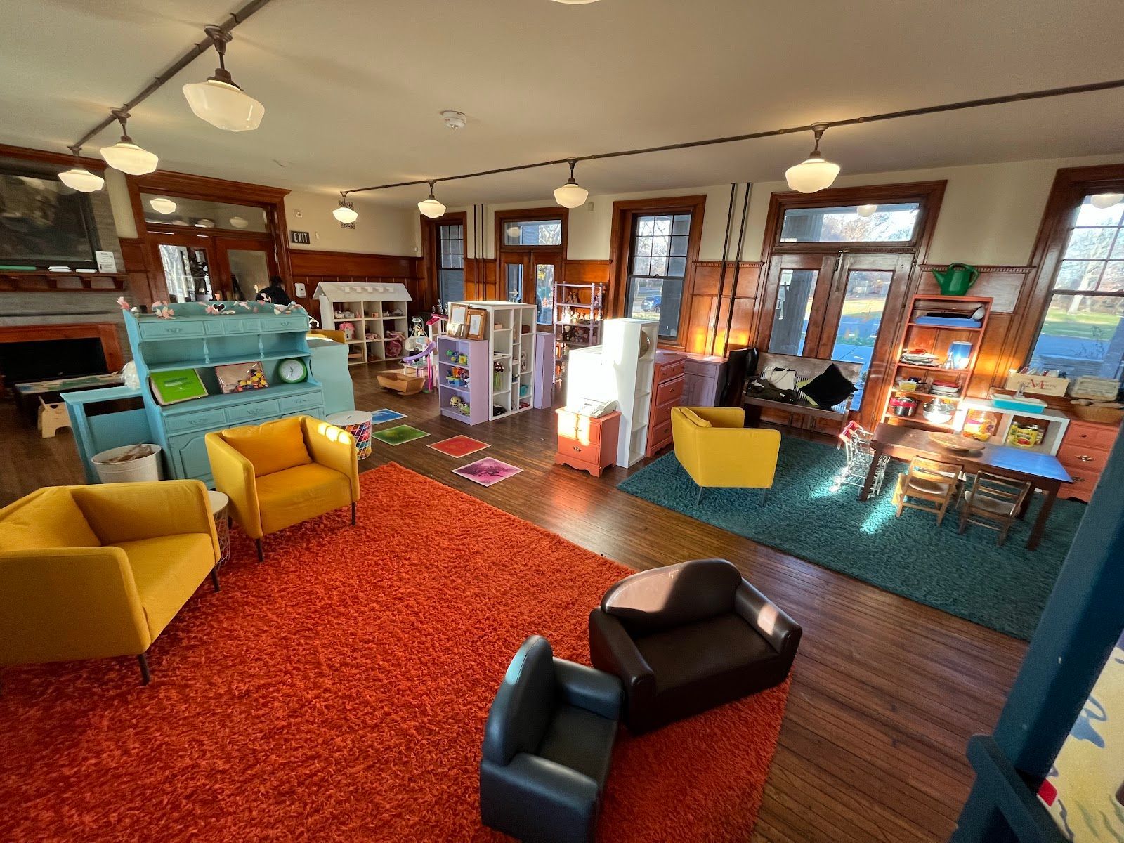 Bright, colorful living room with yellow chairs, a red rug, and large windows in a cozy interior