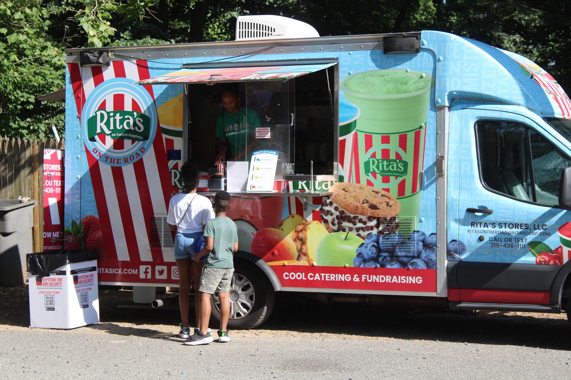 Rita’s Italian ice food truck with two customers ordering at the service window