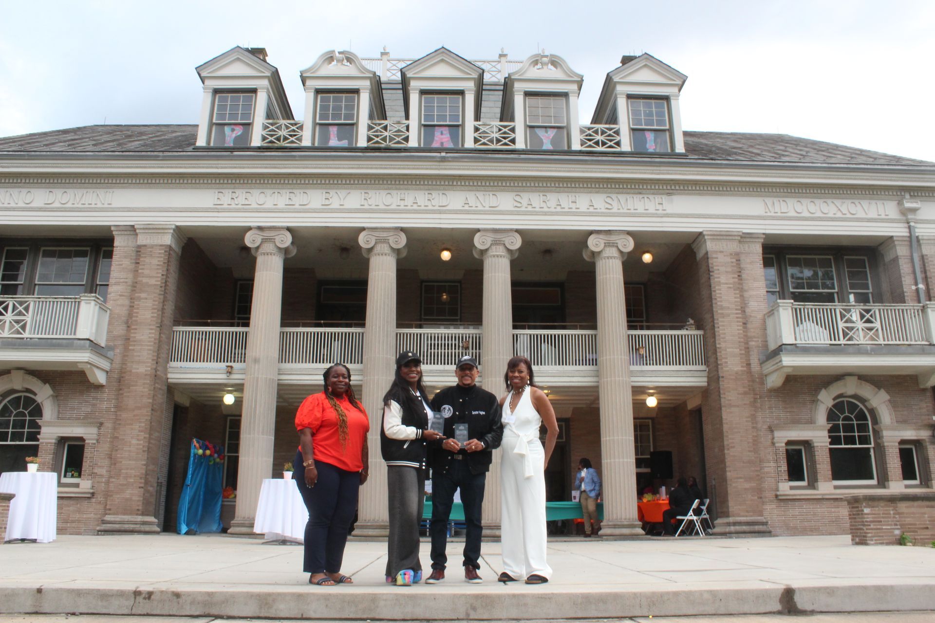 Group posing on steps in front of a large stone mansion-like building