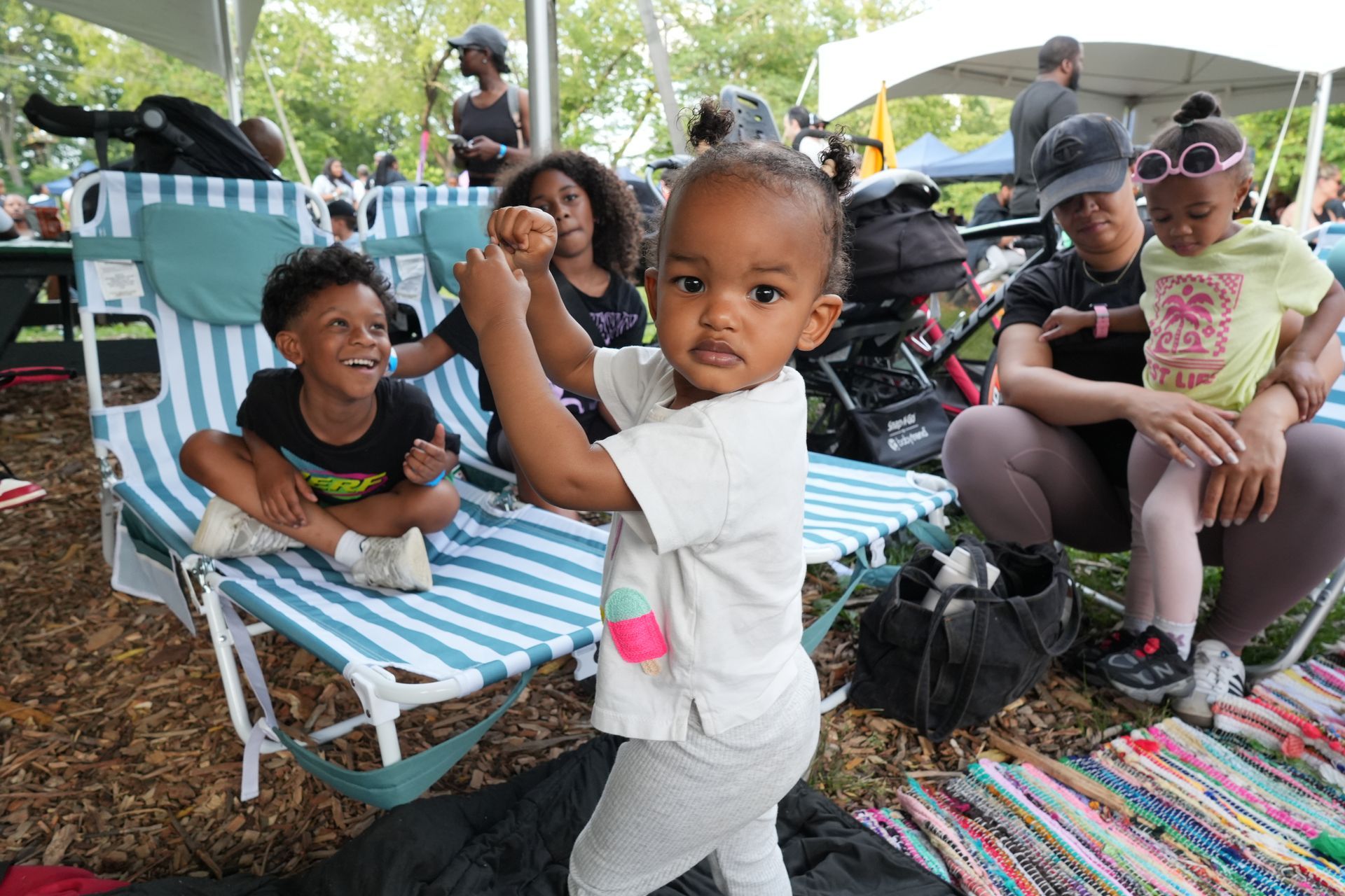 Children relaxing on colorful lawn chairs and blankets at an outdoor gathering