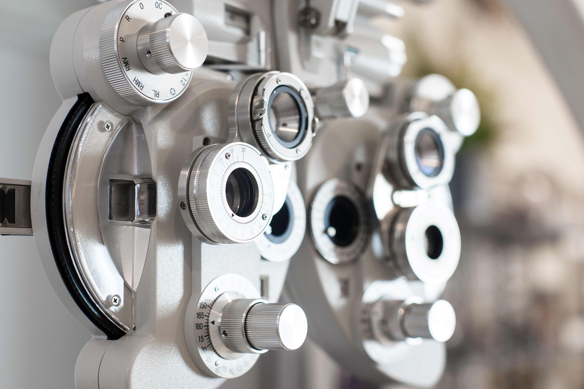 Close-up of an optometry device with adjustment dials used for eye exams and vision testing.