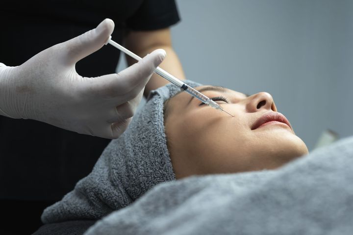 A person receiving a facial injection near their eye.
