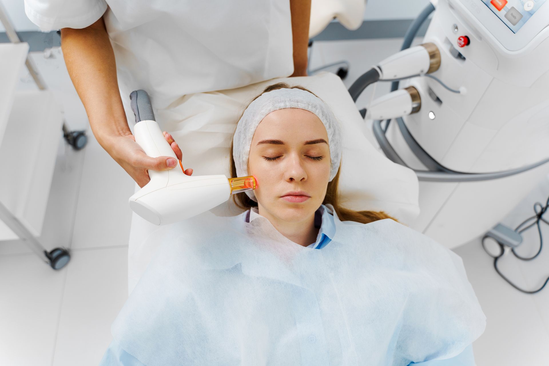 Dental hygienist cleaning a patient’s teeth in a bright clinic, using a handheld tool and suction tube