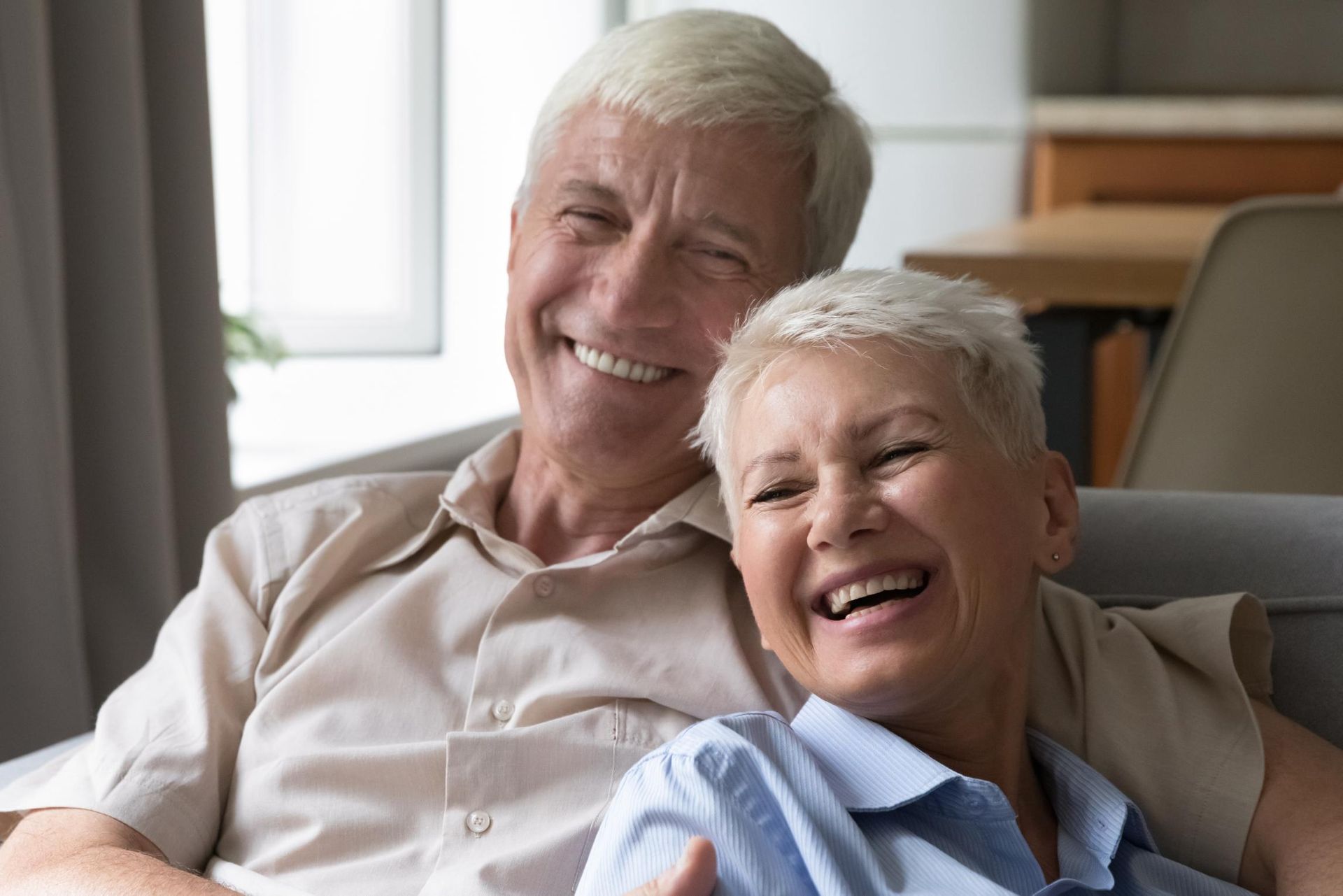 Smiling couple relaxing together on a couch in a bright living room
