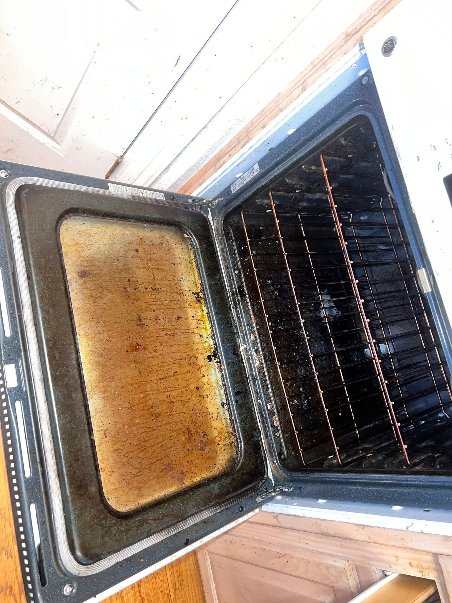 Open oven with baked casserole dish inside and visible oven racks