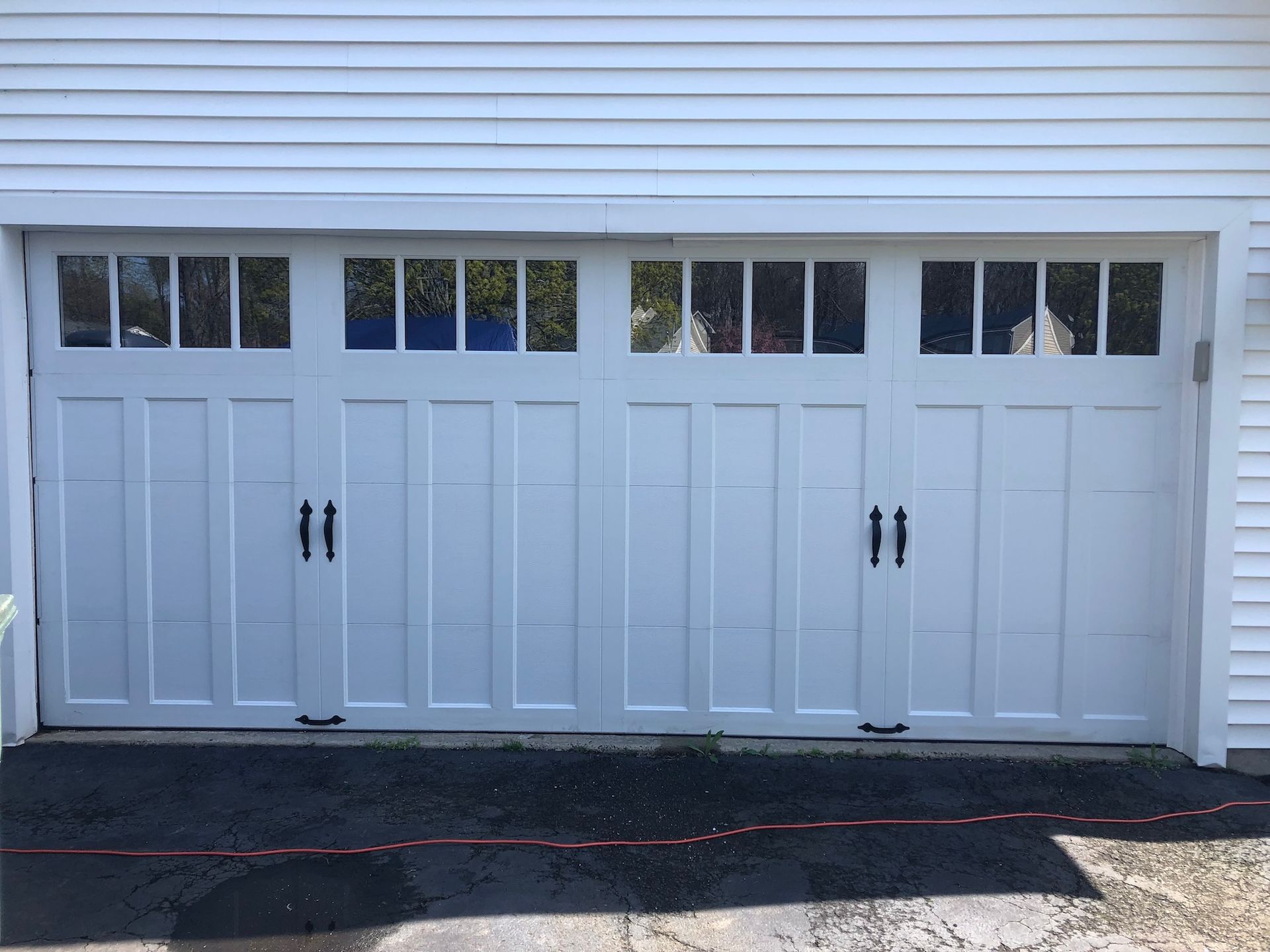 White double garage door with small upper windows on a house exterior