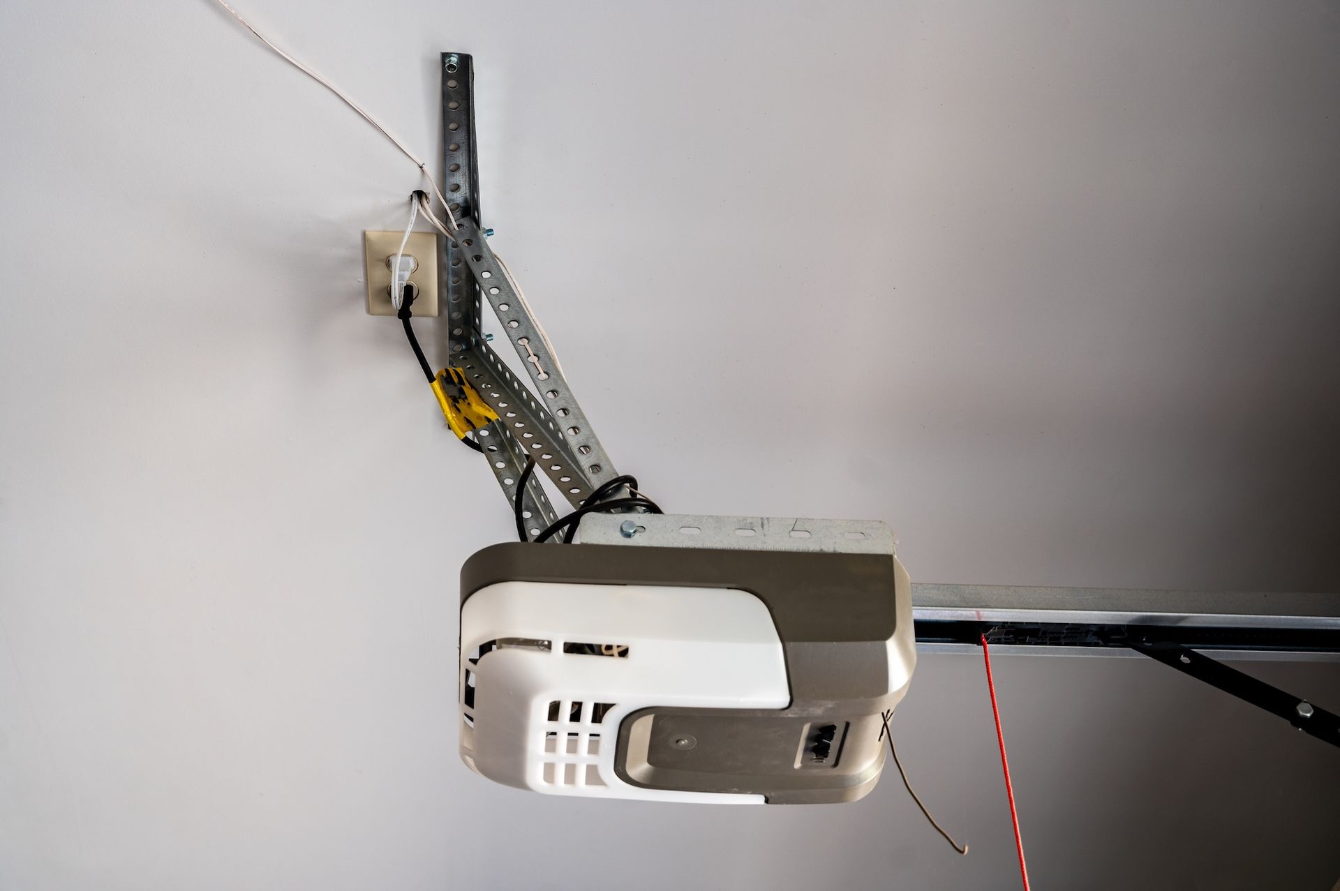 Ceiling-mounted garage door opener with rail and remote wire