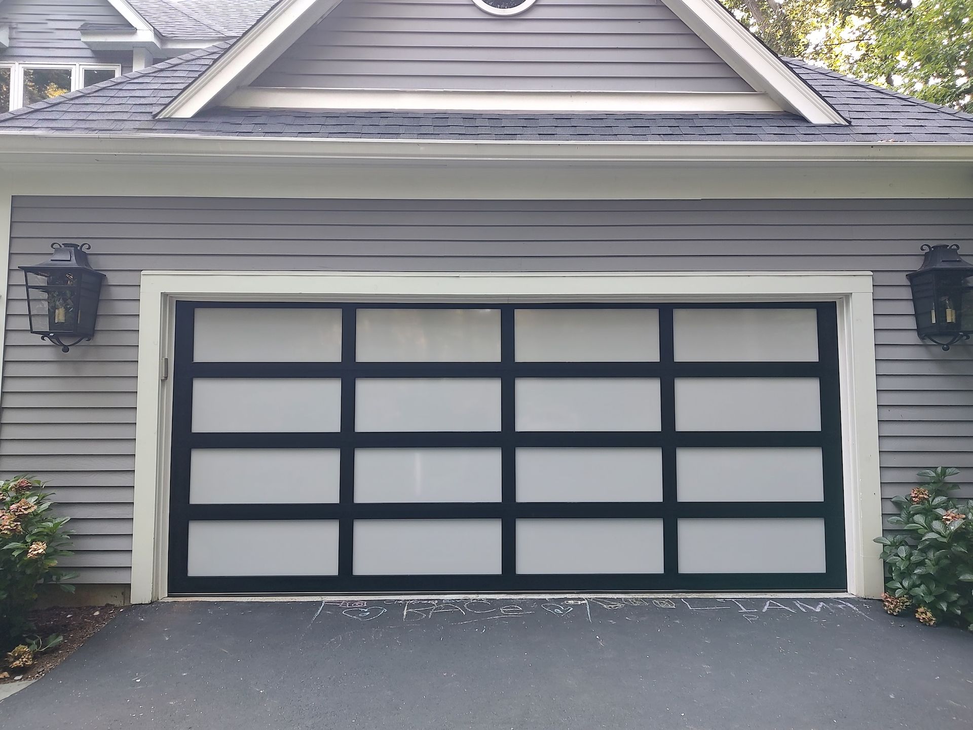 Gray double garage door with black trim on a house exterior