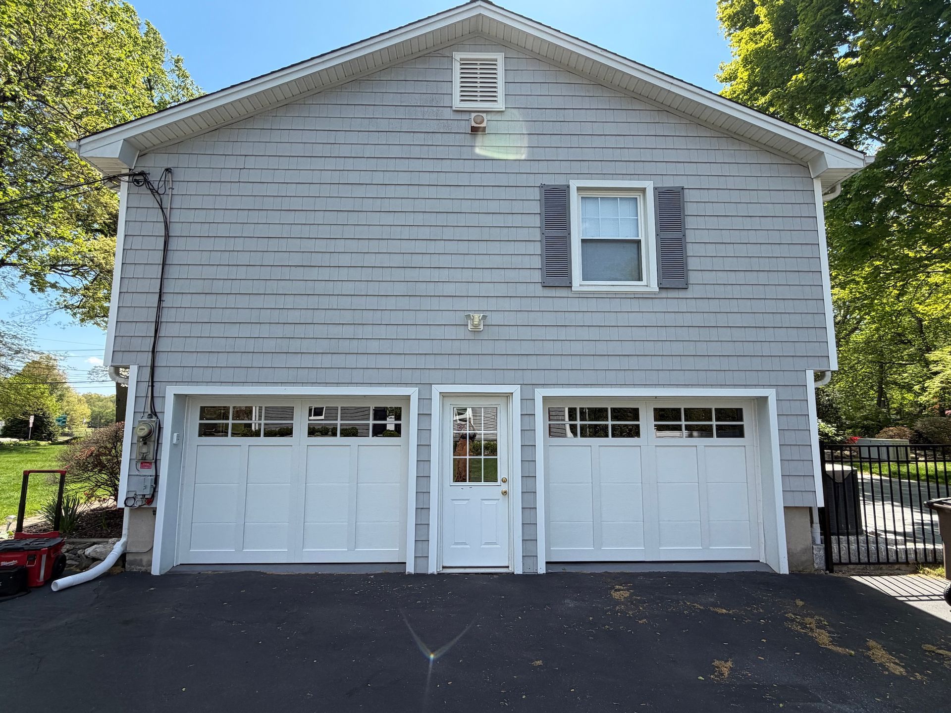 Front view of a gray two-car garage with white doors and a central entry door