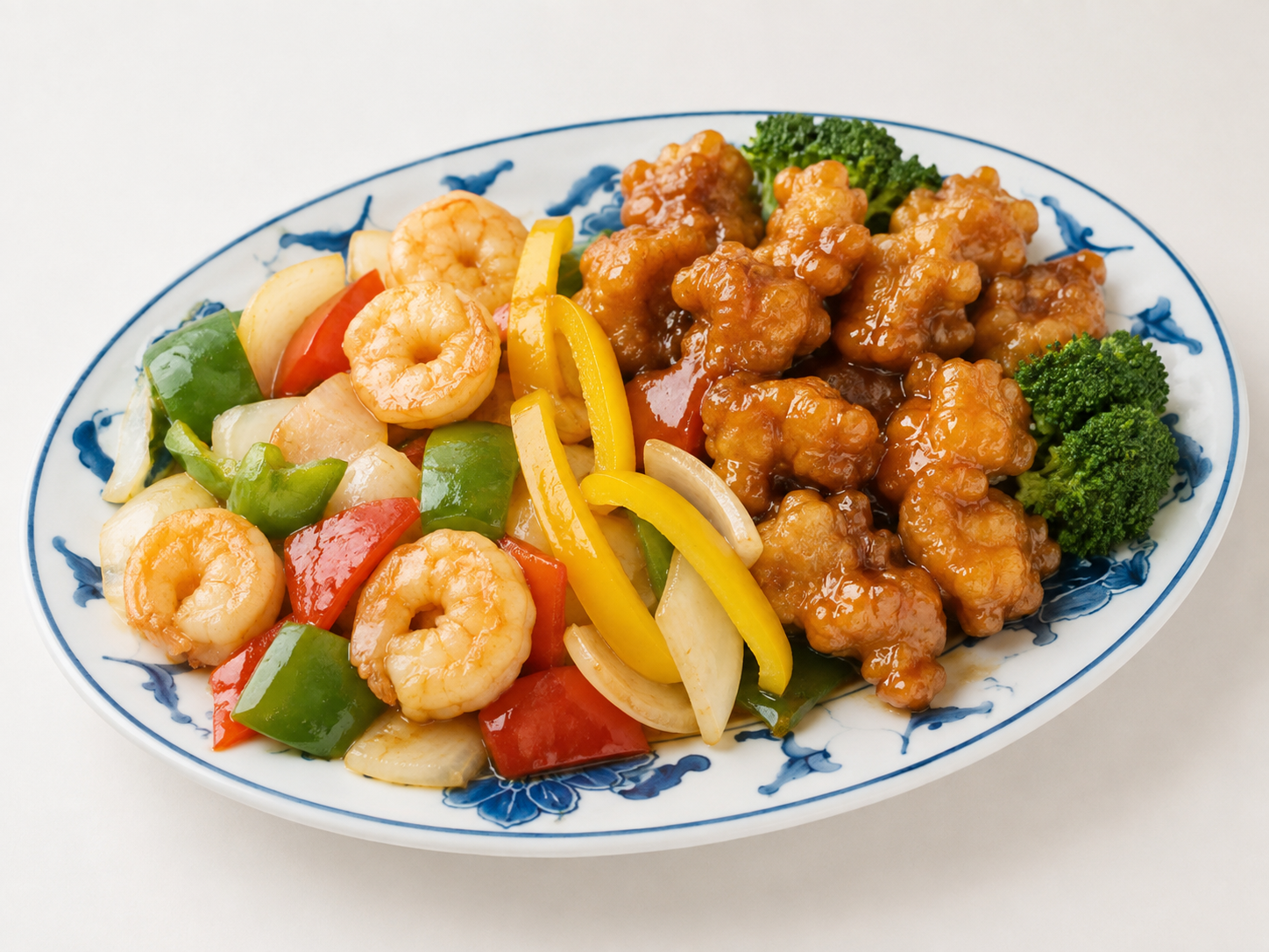 Shrimp and chicken stir-fry with vegetables on a white plate
