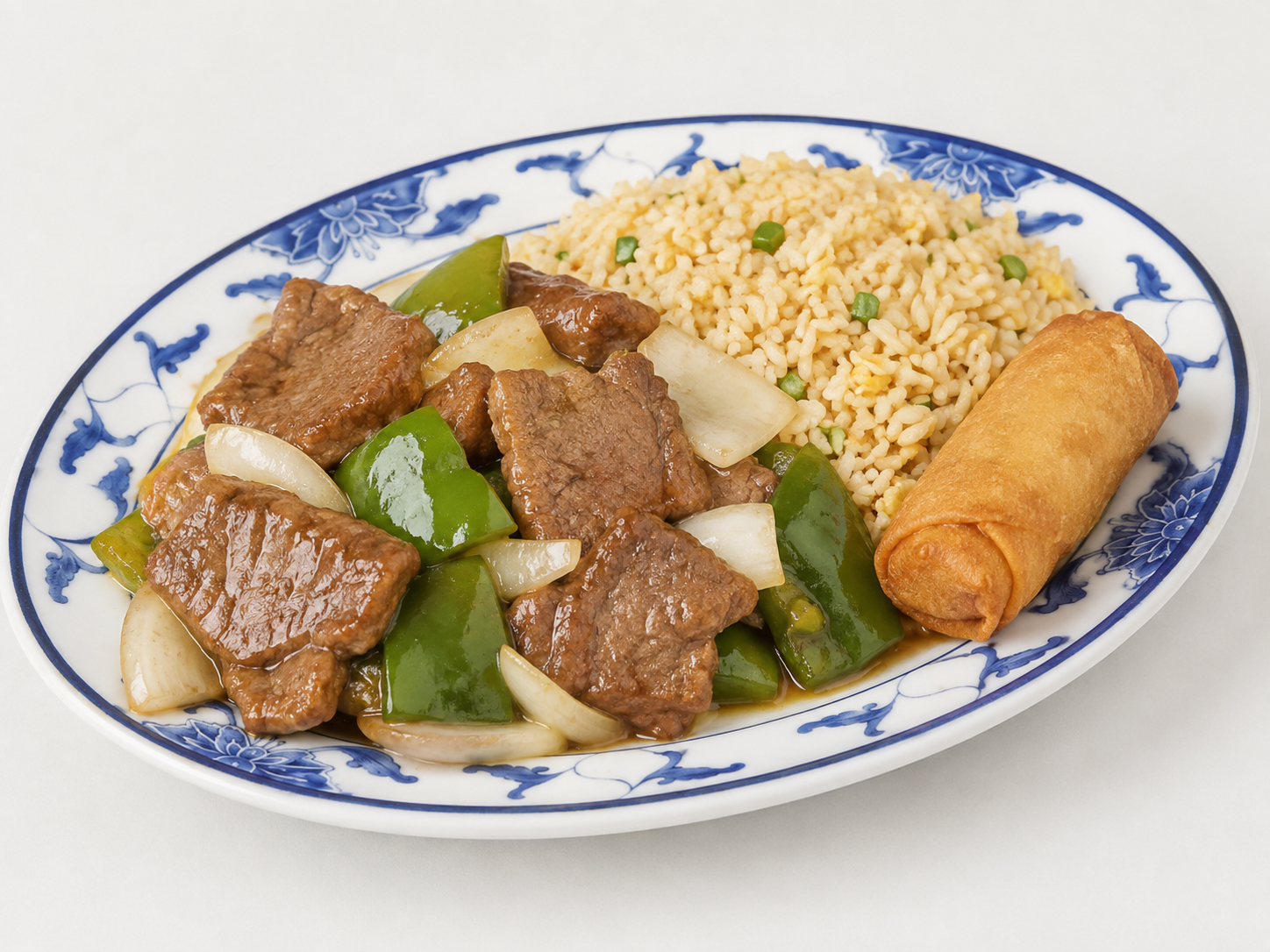 Plate with fried rice, beef and vegetables, and a spring roll on a blue-rimmed dish