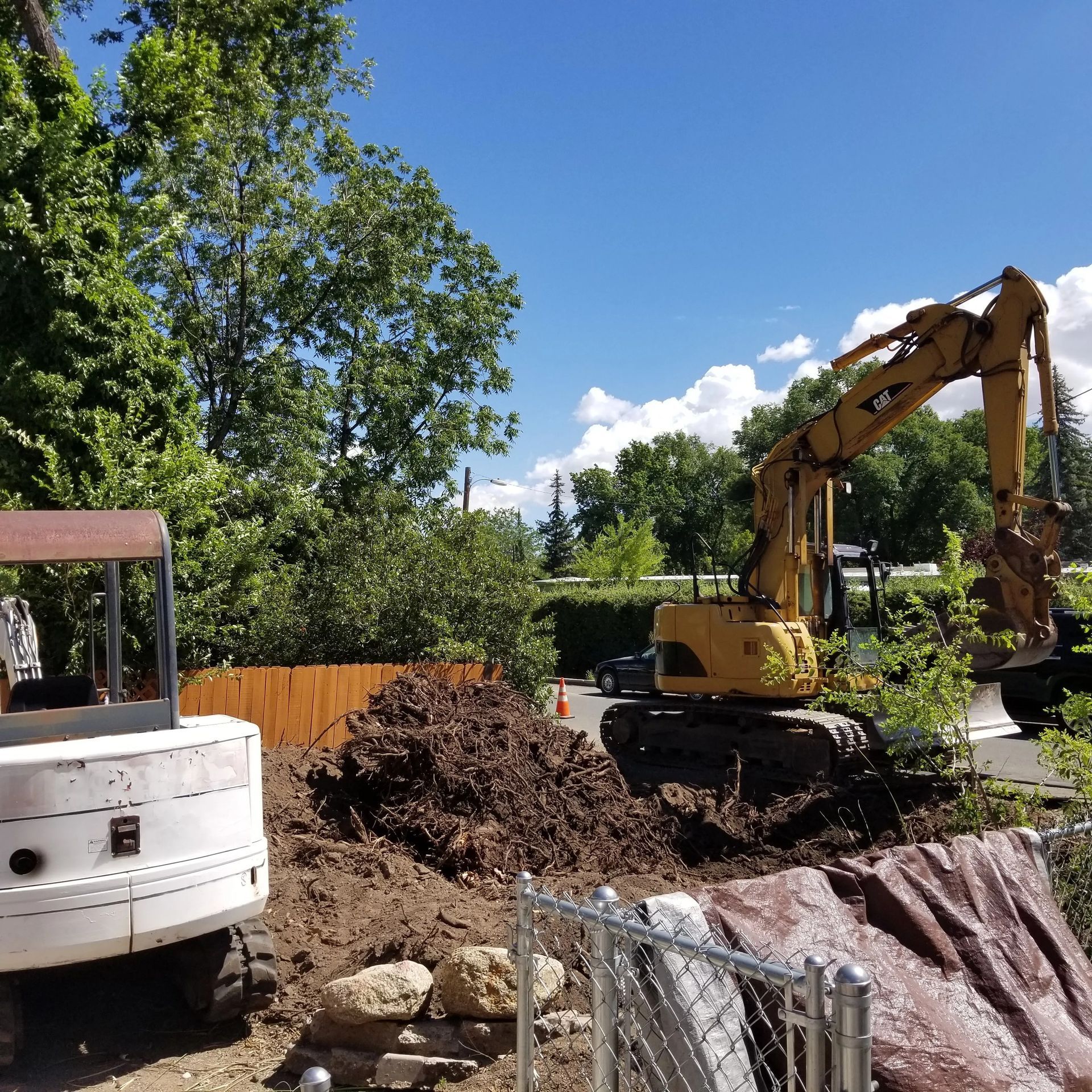 A yellow excavator is digging a hole in the ground