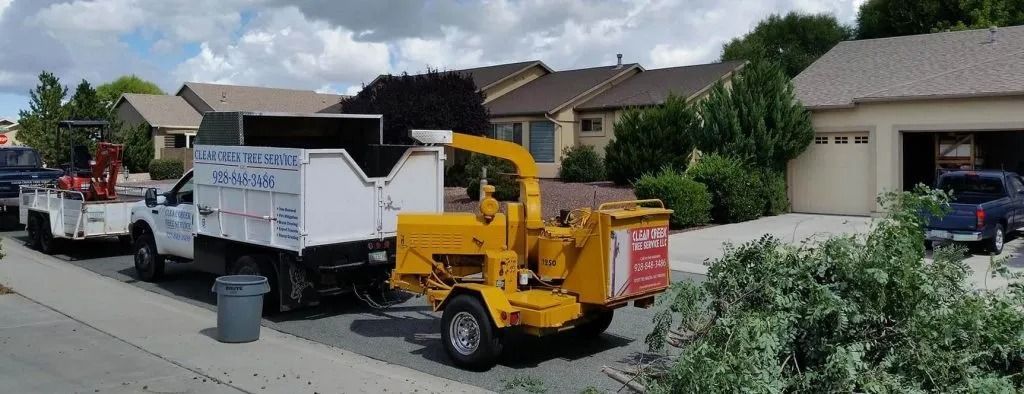 A yellow and white truck is parked in front of a house.
