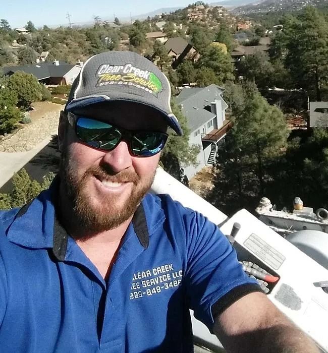 A man wearing a bear creek hat and sunglasses takes a selfie