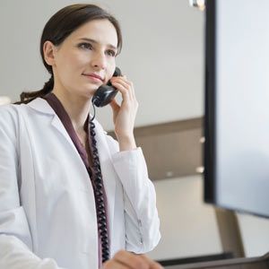 Female periodontist reviewing her website with Solution Web Designs