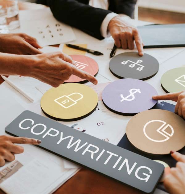 Hands pointing at circular icons on a table, including a dollar sign, with