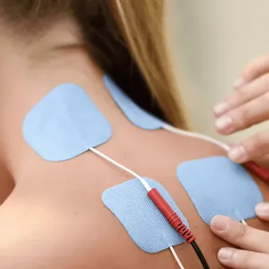 Electrodes attached to a person’s back during physical therapy treatment