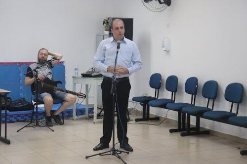 Um homem está em pé na frente de um microfone em uma sala.