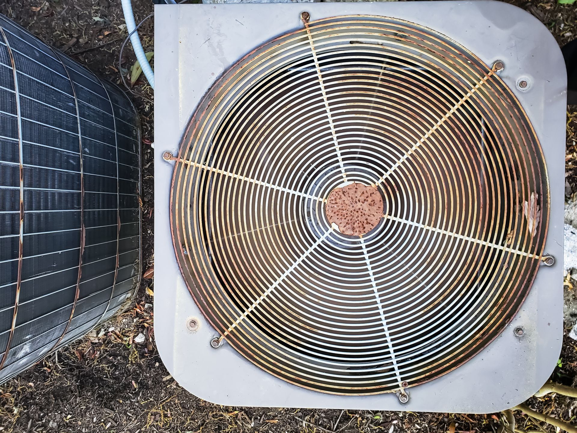 A close up of an air conditioner 's fan on the ground