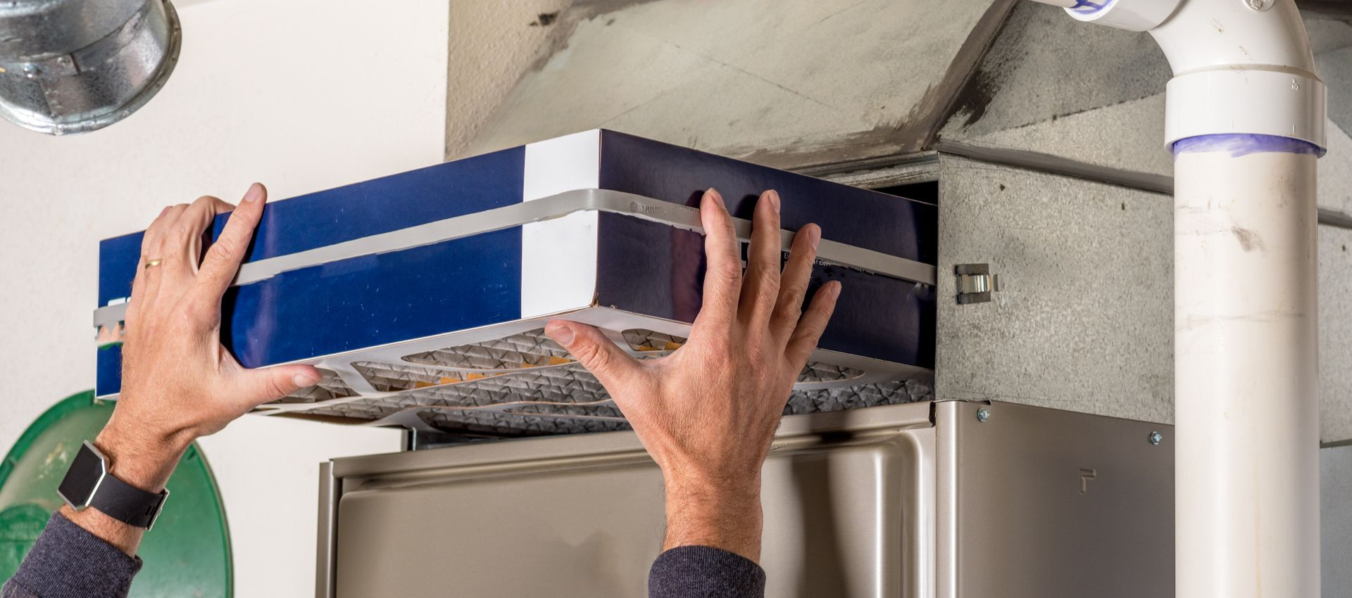 Person replacing an air filter in a home.