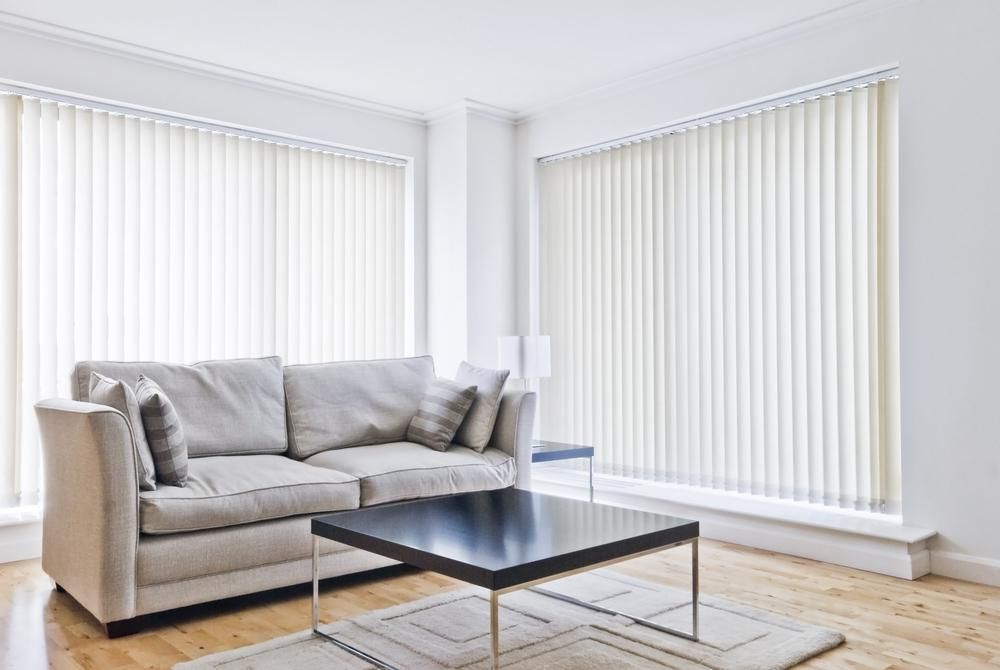 A Living Room With a Couch , Coffee Table , and Vertical Blinds — Atherton Decor Centre In Atherton, QLD
