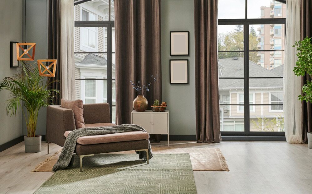 A Living Room With a Chair , Ottoman , and Large Windows — Atherton Decor Centre In Mareeba, QLD