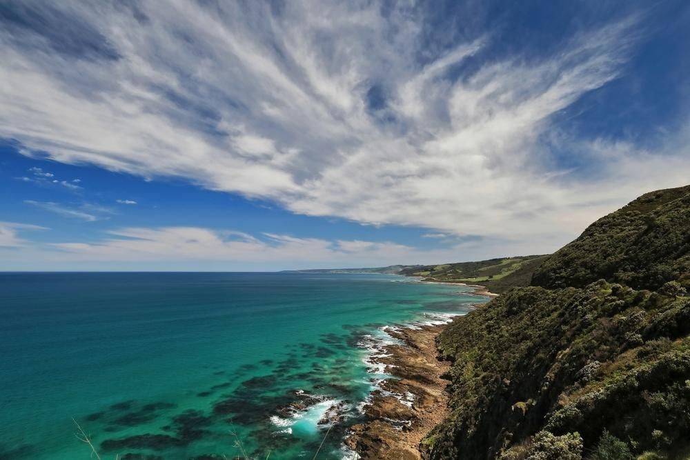 A Cliff Overlooking the Ocean With a Blue Sky and Clouds — Bonanno's Menswear in Shellharbour, NSW