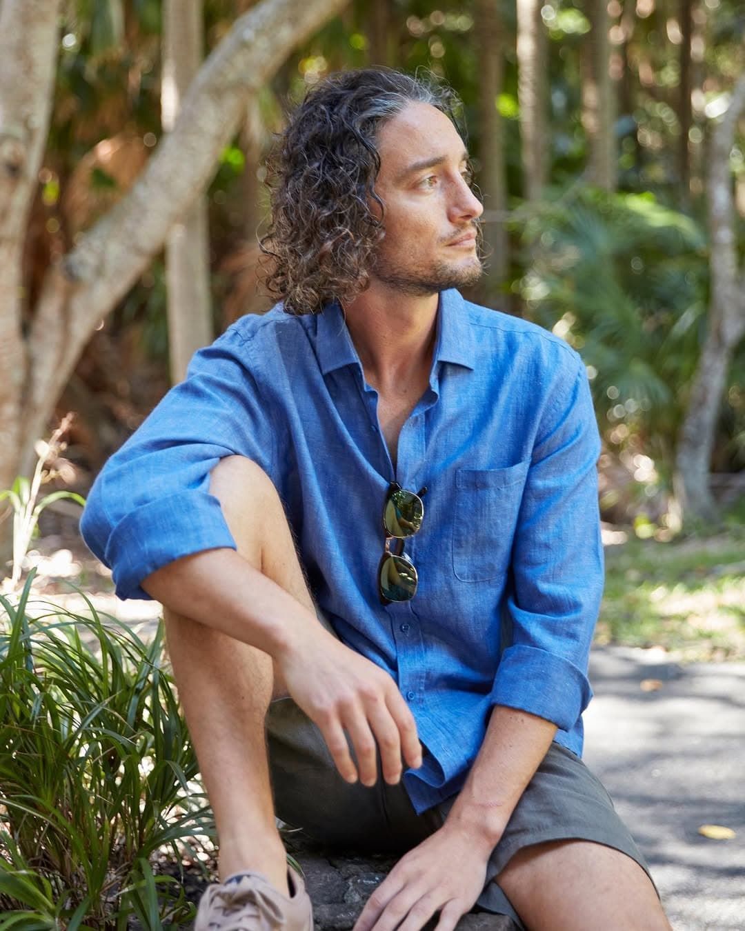 A Man in a Blue Shirt and Shorts is Sitting on a Rock — Bonanno's Menswear in Sutherland, NSW