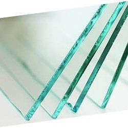 Un gros plan de quatre morceaux de verre transparent empilés les uns sur les autres sur une table.