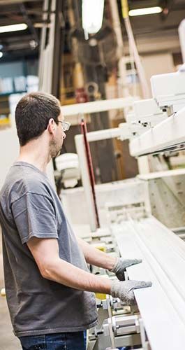 Un homme travaille sur une machine dans une usine.