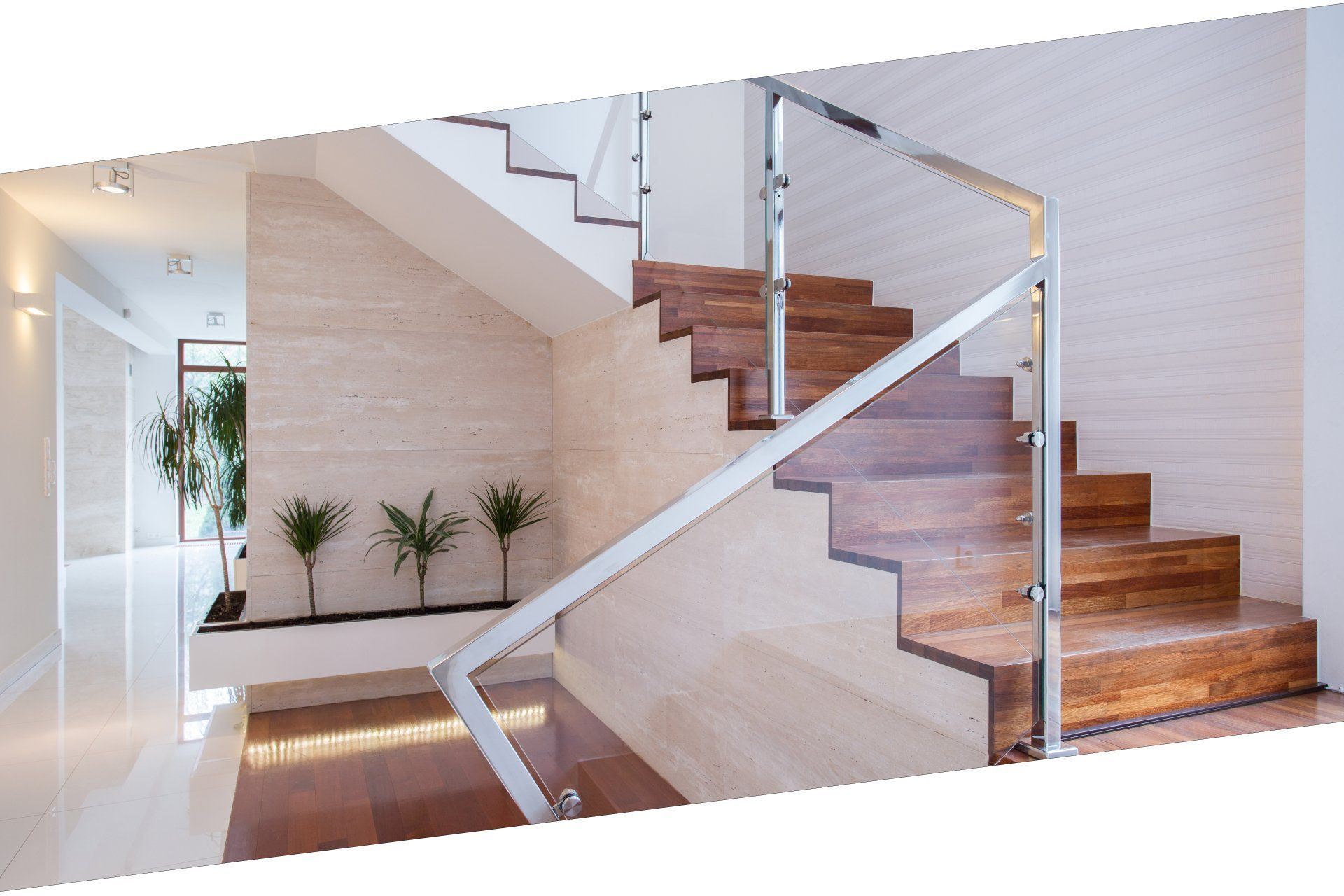 Un escalier en bois avec une rampe en verre dans une maison