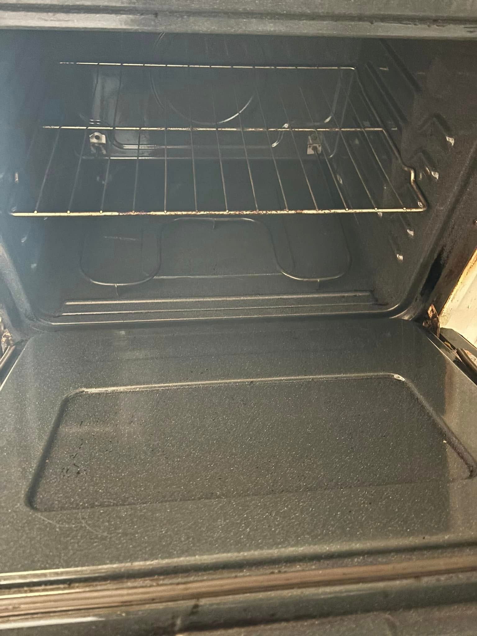 An open oven with a single wire rack inside and a black interior.