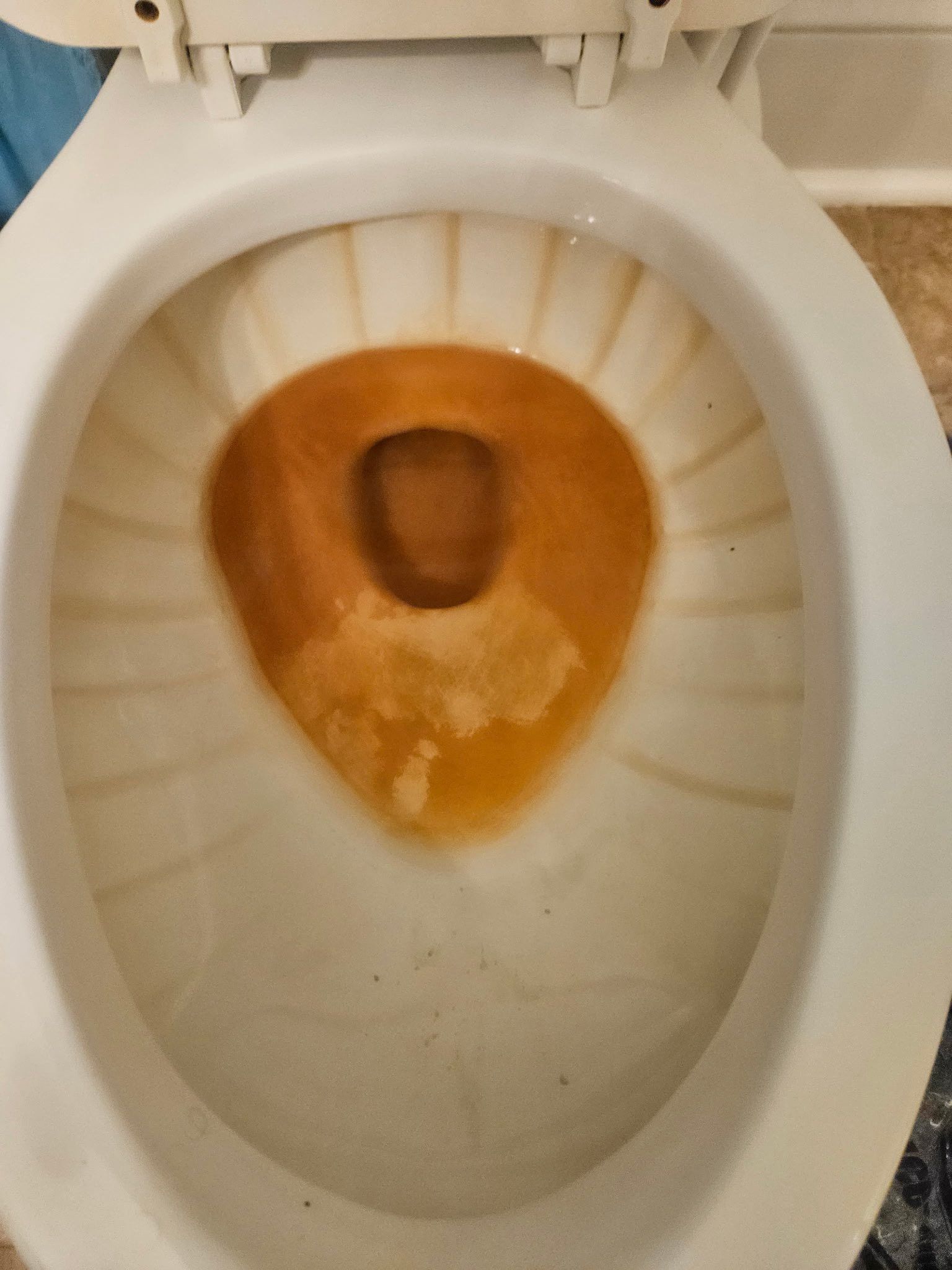 A white toilet bowl with brown staining inside the basin.